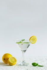 alcohol drinks. Martini glass with cocktail and ice on white background. Cocktail Margarita with lime and green mint on the table. copy space. vertical