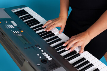 close-up of female hands and fingers of a woman playing an electronic synthesizer, isolated on a...