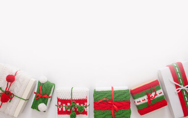Christmas boxes are decorated with knitted ribbons. Isolated white background top view.