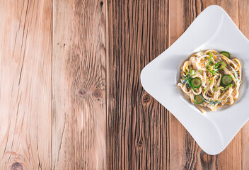 Pasta dish with a sour cream and herbs on wooden boards