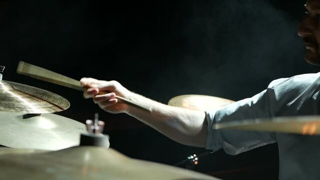 Rock musician playing drums on stage close up.