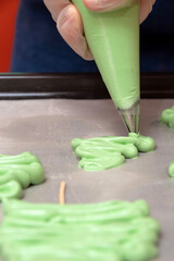 Pastry chef puts Christmas trees from meringue. Selective focus.