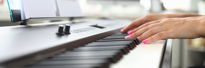 Close up of female pianist playing melody on acoustic stringed musical instrument and using music...