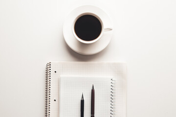 Office desk table with supplies, coffee cup and flower. Top view