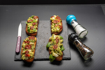 Lots of sandwiches and spices in jars. Sandwiches on a black background. Knife and spices.