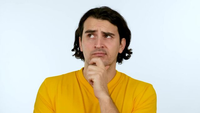 Portrait of unsure, perplexed man looking up and thinking for a solution. Thoughtful expression of a young man over white background.