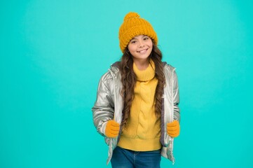 smiling teenage girl in padded or puffer jacket ready to spent winter holiday and vacation in...