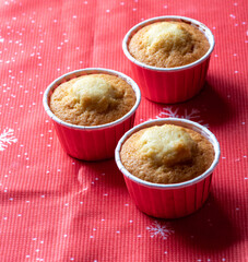 Three of the muffin without decoration in red tins. The view from the top. Selective focus.