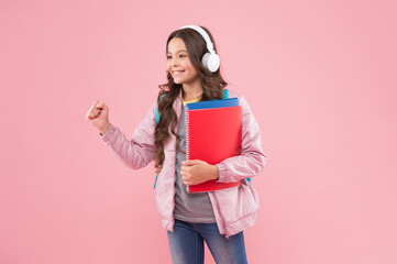 Happy energetic school kid listen to music record playing in headphones pink background, solfeggio