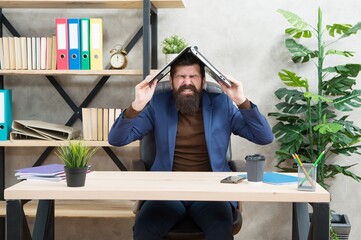 Obraz premium Always stressed. Crazy director hold laptop on head. Bearded man screaming in pain. Headache attack. Got stressed at work. Business stress management. Running business is stressful