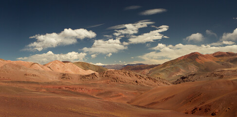 Fototapeta na wymiar Volcanic landscape. Panorama view of the arid desert, brown and red Andes mountains, dry valley and colorful hills in Laguna Brava, La Rioja, Argentina. 