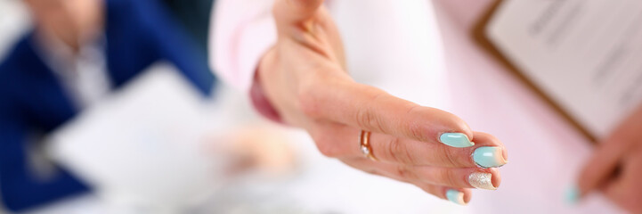 Close up of young woman with elegant manicure and ring offering to shake hands as one-on-one interpersonal greeting ritual