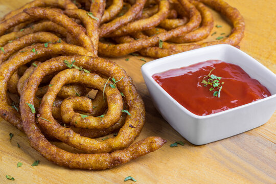 Spiral form fried potatoes with a cup of ketchup sauce