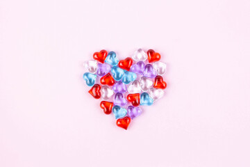 Valentine's Day, wedding, love concept. Big heart made of little colorful hearts isolated on pink background. Top view, flat lay, copy space.