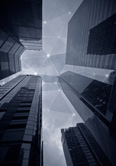 Modern skyscrapers viewed from below. Mesh and connected dots in the sky. Smart cityscape, high technology, connection and wireless communication network concept image in black and white.