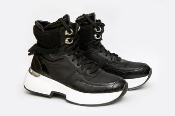 Black casual sports winter women's soft warm boots on a flat white sole on a white background. Trend of the season, modern fashion. Great photo for composing fashion looks