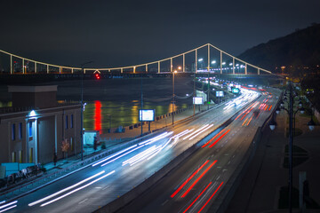 Fototapeta na wymiar Kyiv, Ukraine 11.11.2020: Long exposure view of the road and bridge with illumination at night kyiv