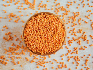 Healthy eating and dietary. Bowl of raw red lentil on white wooden background. Top view. Flat lay. Masoor Dal or Canadian Orange Lentils. Vegetarian super food.