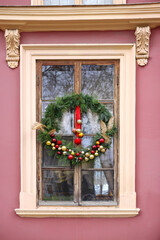 Christmas wreath with red and gold balls on the window
