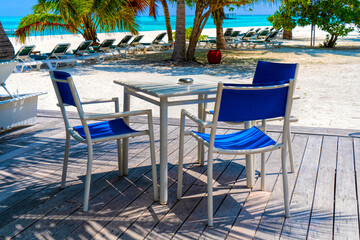 Wooden table and chairs by the tropical warm sea. Maldives