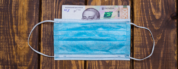 Kyiv, Ukraine 12.04.2020: Ukrainian national currency banknote hryvnia and protective medical mask. Cash of the National Bank of Ukraine.