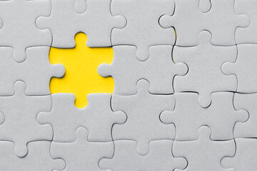 Obraz premium Demonstrating trendy Color of the Year 2021. Illuminating Yellow and Ultimate Gray. Duotone. Multiple grey puzzle pieces put together without one piece on yellow background