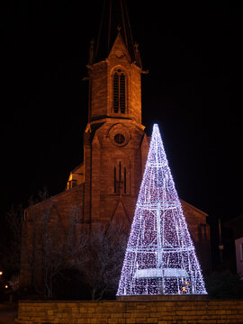 White lightning christmas tree outside in front of church.