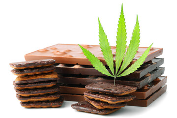 Delicious CBD cannabis chocolate chip cookie, green hemp leaves decoration on white isolated background. Medical marijuana treatment for human consumption. Rasta cookie recipe