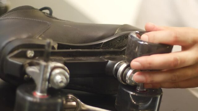 Close up of person repairing a roller skate wheel on a retro pair of rollerskates