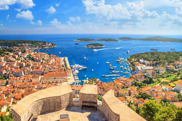 Coastal summer landscape - top view of the City Harbour and marina of the town of Hvar from the fortress, on the island of Hvar, the Adriatic coast of Croatia - obrazy, fototapety, plakaty