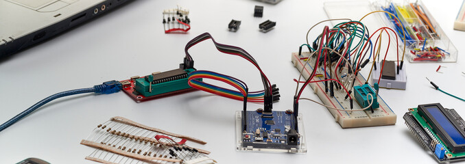 The concept of a microprocessor device assembled on a breadboard.Programmer, Arduino and peripheral...
