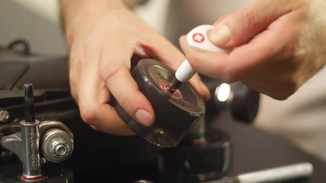 Close up of person repairing a roller skate wheel on a retro pair of rollerskates