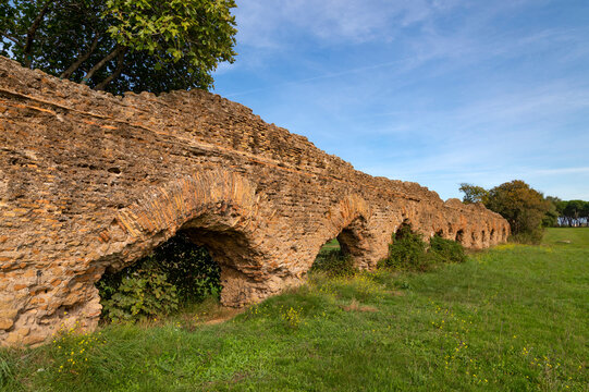 Perspective of the Alexandrian Aqueduct, the last of the Roman aqueducts, built by Emperor Alexander Severus. Detail of the arches and bricks on a sunny day and blue sky centocelle area. Rome.