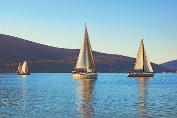 Fototapeta premium Winter Mediterranean landscape with sailing boats on water. Montenegro, Adriatic Sea. View of Bay of Kotor near Tivat city