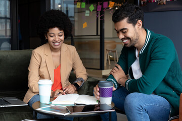 Happy diverse businessman and businesswoman drinking coffee on their break in office