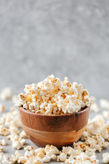 Homemade popcorn in a wooden bowl on a grey background