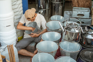 craftsman holding and viewing bucket details while checking in a homeware store