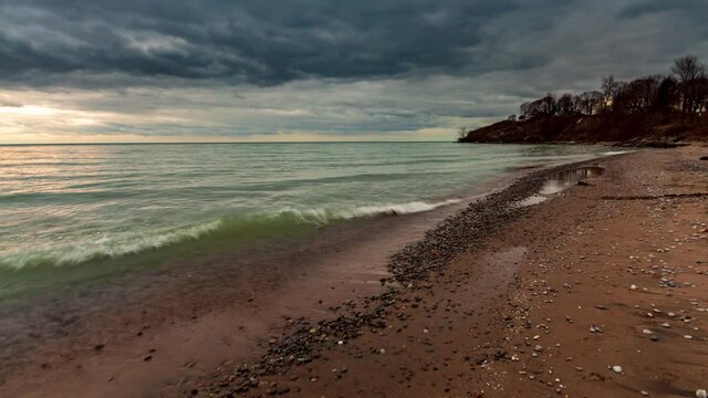 A dramatic time-lapse of a sandy beach with dark clouds moving across the evening sky in Oshawa, Ontario