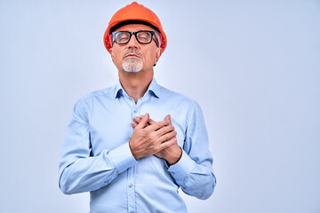 Calm adult architect in safety helmet in studio