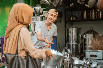 male seller serve woman buyers looking for goods in a homeware store