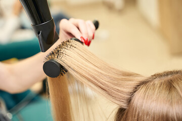 Repair long hair procedure. Haircut at salon. Woman hairstyle. Master hand with brush and fan....
