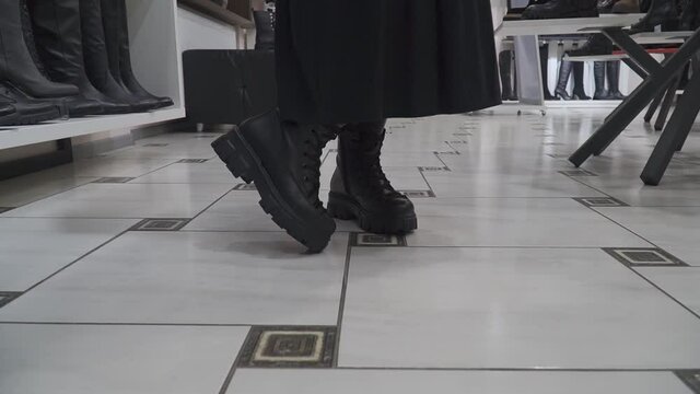 slow motion young women colorfully defile in a shoe store among the counters in a fashionable and beautiful variety of women's shoes