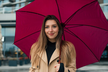 Portrait of beautiful woman standing under umbrella