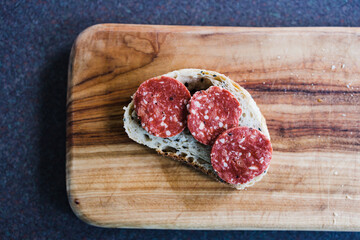 simple food ingredients, plant-based salami slices on bread slice on cutting board