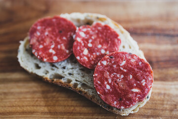 simple food ingredients, plant-based salami slices on bread slice on cutting board