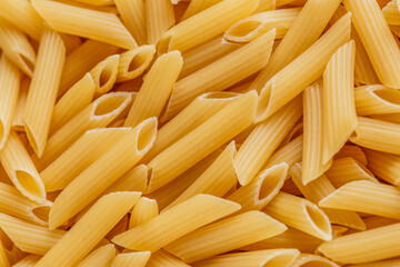 Dry pasta Pennoni Rigati.Pennoni Rigati have shape and yellow color. Pasta is delicious Italian traditional food made from wheat flour like noodles.Dry pasta background.Top view