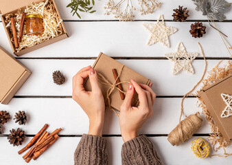 A woman is packing gifts in a craft gift box. Eco friendly Christmas. Wasteless.