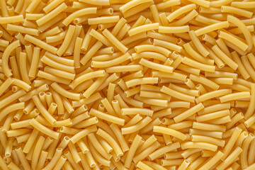 short Italian pasta penne. Pasta is delicious Italian traditional food made from wheat flour like noodles.Dry pasta background.Top view