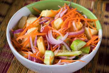 Vegetarian breakfast bowl with boiled potatoes, tomatoes, red onions, carrots and cucumbers