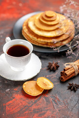 Vertical view of pluffy pancakes with a cup of tea